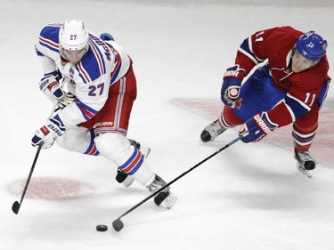 Brendan Gallagher of the Montreal Canadiens (right) and Ryan McDonagh of the New York Rangers battle for the puck in the first period in NHL action at the Canadiens' home opener at the Bell Centre Thursday, October 15, 2015 in Montreal.