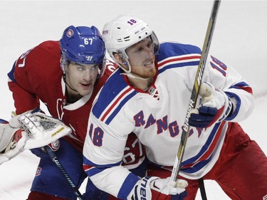 Max Pacioretty (left) of the Montreal Canadiens looks for a shot from the point while being checked by Marc Staal of the New York Rangers in the first period in NHL action at the Canadiens' home opener at the Bell Centre Thursday, October 15, 2015 in Montreal.