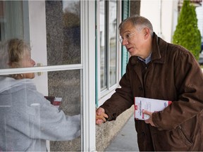 Francis Scarpaleggia, right, Liberal Party candidate for the riding of Lac-Saint-Louis, greets a resident as he goes door to door campaigning in Pointe-Claire in Montreal on Saturday, Oct. 17, 2015.