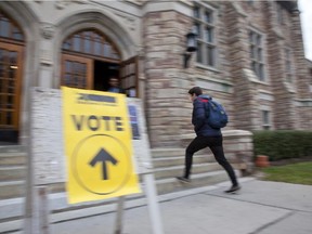 Voters arrive and leave a polling station at Victoria Hall in the riding of N.D.G.-Westmount in Montreal, Monday October 19, 2015.