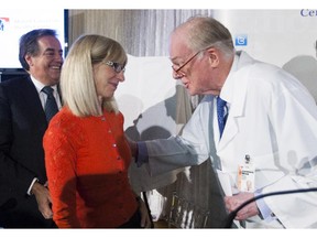 Dr. David Mulder (right) speaks with Radio- Canada journalist Isabelle Richer in Montreal Tuesday, October 20, 2015 at the end of a press conference honouring Mulder's contribution to trauma care. The hospital has named its trauma centre after him--the Dr. David S. Mulder Trauma Centre. Richer was treated at the Montreal General Hospital after she was struck on her bicycle by a truck. MUHC president and director general Normand Rinfret is in the background.