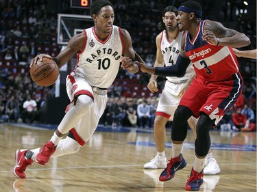 Toronto Raptors DeMar DeRozan drives against Bradley Beal of the Washington Wizards as Raptor Luis Scola watches during National Basketball League pre-season game in Montreal Friday October 23, 2015.