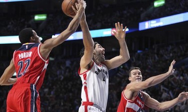 Toronto Raptors Luis Scola has the ball knocked out of his hand by Washington Wizards Otto Porter while team-mate Kris Humphries helps out during National Basketball League pre-season game in Montreal Friday October 23, 2015.