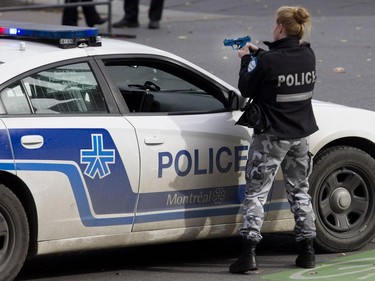A Montreal police officer secures the perimeter during a terror attack simulation in Montreal on Saturday, Oct. 24, 2015.