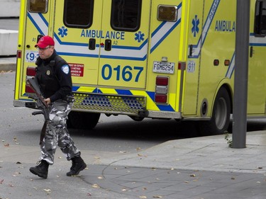 A Montreal police officer removes the terrorist's weapon during a terror attack simulation in Montreal on Saturday, Oct. 24, 2015.