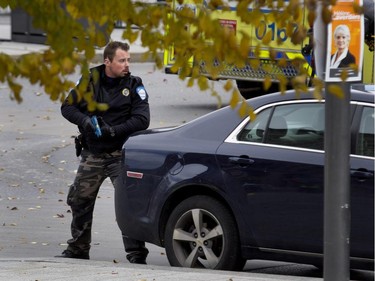 A Montreal police officer secures the perimeter during a terror attack simulation in Montreal on Saturday, Oct. 24, 2015.