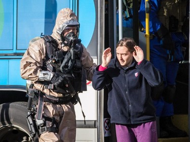 An actor is escorted by SPVM tactical units during a terrorism attack simulation held at CFB Montreal (Longue-Pointe) military base in Montreal on Saturday, Oct. 24, 2015.