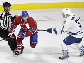 Dion Phaneuf of the Toronto Maple Leafs confronts Dale Weise of the Canadiens in the second period at the Bell Centre on Saturday, Oct. 24, 2015 in Montreal in front of linesman Derik Nansen. Weise had checked Phaneuf moments earlier and Phaneuf's physical comebacks resulted in his receiving a penalty.