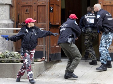 Montreal police enter the Black Watch Armoury looking for suspects during a terror attack simulation in Montreal on Saturday, Oct. 24, 2015.