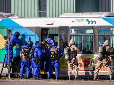 Montreal police, in brown, and RCMP tactical units, in blue, hold a terrorism attack simulation at the CFB Montreal (Longue-Pointe) military base in Montreal on Saturday, Oct. 24, 2015.