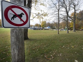 One of many no-dog signs installed around municipal park/green space at the corner of Rue de l'Eglise and Bellevue in Vaudreul-sur-le-Lac, Saturday, October 24, 2015. Town council has banned dogs in city parks, even if on a leash, because of too much poop is left behind when dogs use the park.
