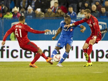 Didier Drogba of the Montreal Impact fires a shot under pressure from Ahmed Kantari and Josh Williams of Toronto FC in the second half at Saputo stadium in Montreal Sunday, October 25, 2015. It was the final game of the M.L.S. season for the Impact