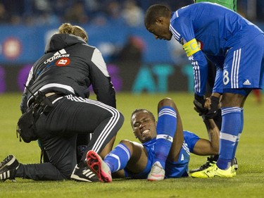 Didier Drogba of the Montreal Impact is tended to by a training staff member and teammate Patrice Bernier after being hurt in the second half of a game against Toronto FC at Saputo stadium in Montreal Sunday, October 25, 2015. He came out briefly, but later returned limping to the pitch. It was the final game of the M.L.S. season for the Impact