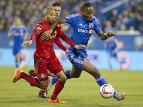 Forward Didier Drogba of the Montreal Impact tries to fend off Justin Morrow of Toronto FC in the second half of the final game of the MLS season for the Impact at Saputo stadium in Montreal on Sunday, Oct. 25, 2015.