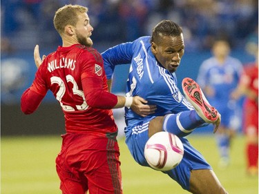 Forward Didier Drogba (right) of the Montreal Impact tries to control an incoming ball while being closely defended by Josh Williams of Toronto FC in the first half of the final game of the MLS season for the Impact at Saputo stadium in Montreal on Oct. 25, 2015.