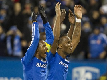 Montreal Impact teammates Patrice Bernier (left) and Didier Drogba salute fans after their team defeated Toronto FC in the final game of the M.L.S. season for the Impact at Saputo stadium in Montreal Sunday, October 25, 2015.