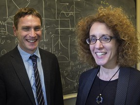 Andrew Cumming, left, associate professor of physics and associate director of the McGill space institute with Victoria Kaspi, Lorne Trottier Chair in astrophysics and cosmology and director of the McGill space institute, stand in front of quantum mechanics math formulas at the institute on Wednesday October 28, 2015.