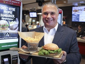 McDonald's franchisee John Delorio holds up new customizable burger platter, which was ordered at a self-serve kiosk next to him, at MacDonald's on Lacordaire St., in Montreal on Wednesday, October 28, 2015.
