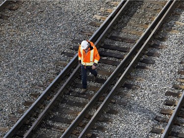 A CP Rail worker walks the tracks near a derailed train in Montreal on Thursday October 29, 2015. One railway car plunged into the backyard of a residential complex next to the tracks.