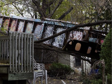 A train wagon sits in the backyard of a home after it derailed in Montreal on Thursday October 29, 2015. There were no injuries and the train car did not hit the residential building.