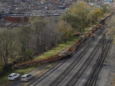 A CP Rail crew inspects a derailed train in Montreal on Thursday October 29, 2015. One railway car plunged into the backyard of a residential complex next to the tracks.