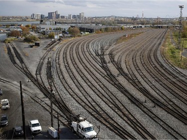 CP Rail crews, bottom left, wait in a rail yard a few hundred metres from a derailed train in Montreal on Thursday October 29, 2015. One railway car plunged into the backyard of a residential complex next to the tracks.