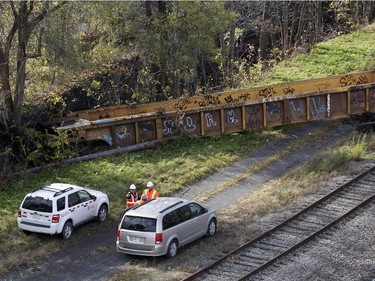 CP Rail crews inspect a derailed train in Montreal on Thursday October 29, 2015. One railway car plunged into the backyard of a residential complex next to the tracks.