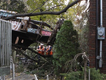 CP Rail crews inspect a derailed train in Montreal on Thursday October 29, 2015. One railway car plunged into the backyard of a residential complex next to the tracks.