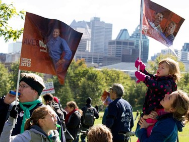 A family joins a crowd estimated at over 100,000 people on Mount Royal as they take part in coalition of public-sector unions demonstration in Montreal on Saturday October 3, 2015.  The groups are protesting the Couillard government's contract offer to unions representing provincial level workers.