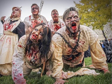 Noemie Larocque, left, and Maxence Portug lead their gang of zombies out of the insane asylum as they take part in Montreal's Zombie Walk on Saturday, October 31, 2015.