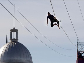 California daredevil Ryan Robinson catches himself as he falls during a 1,000-foot-long slackline in the Old Port of Montreal on Sunday October 4, 2015.