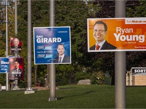 Federal election posters in the riding of Lac-Saint-Louis for candidates Francis Scarpaleggia of the Liberal Party, left, Eric Girard of the Conservative Party, centre, and Ryan Young of the NDP. (Dario Ayala / Montreal Gazette)