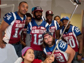Sara Gibeau uses a selfie stick to get a picture with the Montreal Alouettes as they visit Ste-Justine Hospital in Montreal on Tuesday October 6, 2015.