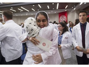 Saba Balvardi, facing, gets a hug from Abrar Al Jassim after receiving their white coats at a ceremony at McGill University on Sept. 25, 2015. The ceremony affords medical students an opportunity to reflect on the obligations they are about to undertake.