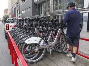 A technician stacks Bixi bikes on a trailer for redistribution in Montreal, Sept. 29, 2015.