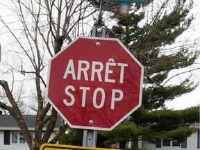 A stop sign in the centre of the image with a tree in the background, against a grey sky.