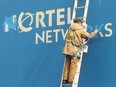 A worker paints in the letters before new signs were hung over old Nortel Networks signs in 2012, signifying the end of an era.