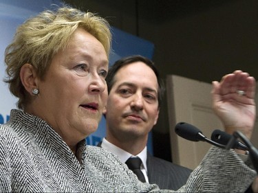 Quebec Premier Pauline Marois gestures as she announce the party's stand on the provincial debt as Quebec treasury board chair Stéphane Bédard, Wednesday March 12, 2014 in Quebec City.