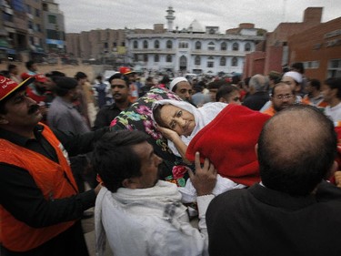 People rush an injured woman to a local hospital in Peshawar, Pakistan, Oct. 26, 2015.