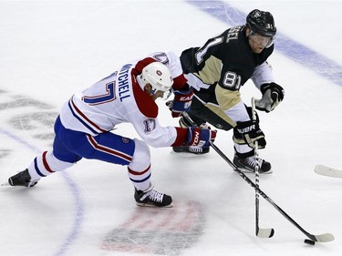 Montreal Canadiens' Torrey Mitchell (17) and Pittsburgh Penguins' Phil Kessel (81) battle for possession of the puck during the first period of an NHL hockey game in Pittsburgh Tuesday, Oct. 13, 2015.