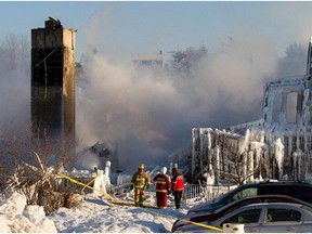 Firefighters stand by the smouldering remains of a seniors residence in L'Isle-Verte, Qc. Thursday January 23, 2014.