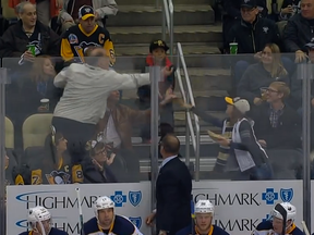 A grown man dives in front of a little to catch a puck during a Pittsburgh Penguins-Buffalo Sabres game Oct. 29, 2015.