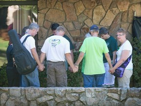 People hold a prayer circle outside Snyder Hall on the campus of Umpqua Community College on October 5, 2015 in Roseburg, Oregon. Despite crime scene tape still being stretched around large areas of the school, the campus was open to staff and students today for the first time since last Thursday when 26-year-old Chris Harper-Mercer went on a shooting rampage in Snyder Hall killing nine people and wounding another nine before he was killed. Classes are not scheduled to resume until next week.