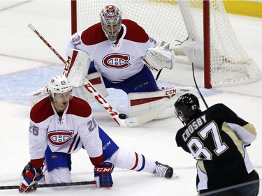 Pittsburgh Penguins' Sidney Crosby (87) gets a shot off in front of Montreal Canadiens goalie Carey Price (31) and Montreal Canadiens' Jeff Petry (26) during the first period of an NHL hockey game in Pittsburgh Tuesday, Oct. 13, 2015.