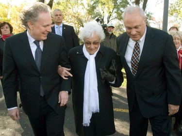Slain Quebec MP, Pierre Laporte's  son, Jean (right) holds his mother's (Francoise) arm with Quebec Premier, Jean Charest  in St Lambert, on the south shore of Montreal, Sunday, October 17, 2010, for the unveiling of a plaque commemorating the 40th anniversary of  his murder in October, 1970  during the October Crisis.