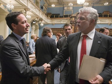 Quebec Premier Philippe Couillard, right, speaks with Opposition Leader Stéphane Bédard after a special session at the Quebec legislature, Thursday July 3, 2014 in Quebec City.