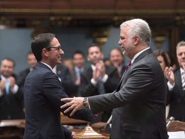 Quebec Opposition MNA Stéphane Bédard, left, shakes hand with Quebec Premier Philippe Couillard, after he announced his decision to resign, Thursday, October 22, 2015 at the legislature in Quebec City.