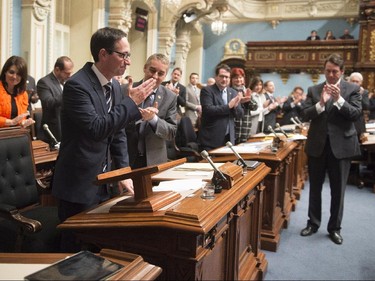 Quebec Opposition MNA Stéphane Bédard bids farewell to politics as Quebec Opposition Leader Pierre-Karl Peladeau, right, and members of the legislature applaud, after he announced his decision to resign, Thursday, October 22, 2015 at the legislature in Quebec City.