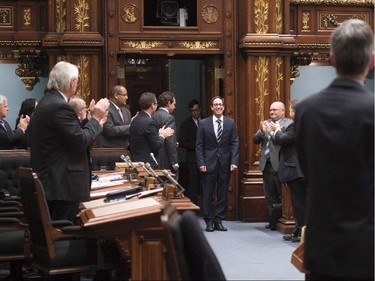 Quebec Opposition MNA Stéphane Bédard, centre, stands as members applaud after he announced his decision to resign, Thursday, October 22, 2015 at the legislature in Quebec City. .
