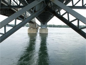 The Mercier bridge is reflected in the moving water of the St. Lawrence River.